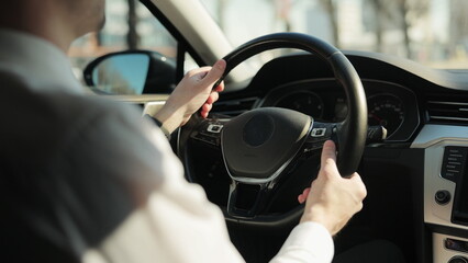 Stylish bearded adult man driving elegant car across city. Business people lifestyle. Weekend journey.