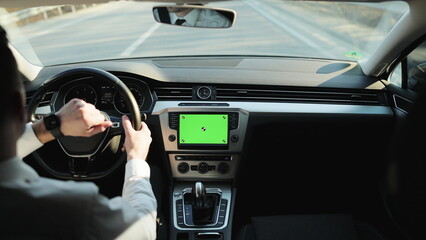 Back view of classic casual businessman in white shirt using smart watch on his hands while driving a car with greenscreen mock-up display dashboard service menu application. Navigation. Map. Driver.