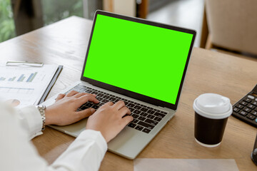 Close up business hands typing on laptop keyboard with green screen. Business hands surfing the internet.