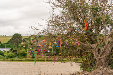 Fototapeta na wymiar Beach art created by artisans hand crafted and hung in natural trees on the beach