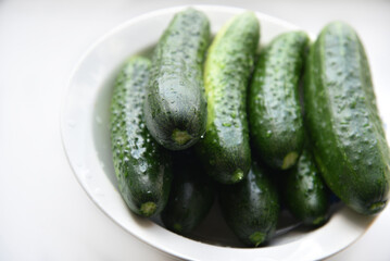 Green juicy cucumbers on a white background.