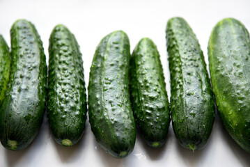 Green juicy cucumbers on a white background.