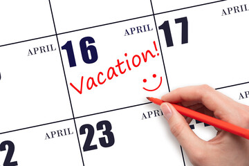 A hand writing a VACATION text and drawing a smiling face on a calendar date 16 April. Vacation...