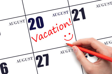 A hand writing a VACATION text and drawing a smiling face on a calendar date 20 August. Vacation...