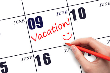 A hand writing a VACATION text and drawing a smiling face on a calendar date 9 June. Vacation...