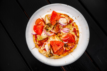 pita pizza with Mozzarella cheese, ham, mushrooms, salami. Italian pizza on wooden table background outdoor
