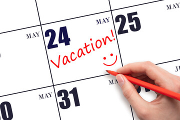 A hand writing a VACATION text and drawing a smiling face on a calendar date 24 May. Vacation...