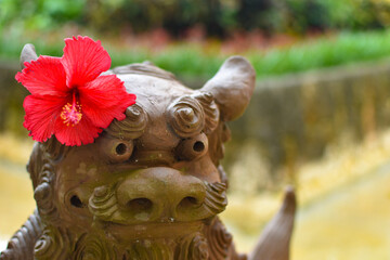 ハイビスカスの髪飾りを付けたシーサー © FURISHO