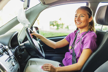 A confident female healthcare professional drives to work in a hospital or medical clinic. Nurse...