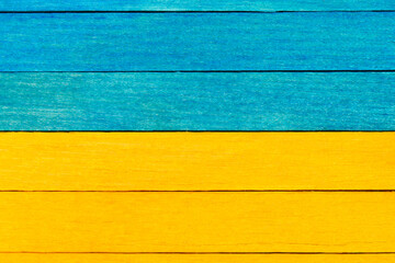 Wooden textured boards in blue and yellow colors . Blue and yellow separated wooden background. 