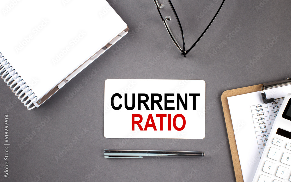 Aufkleber current ratio text written on card with notebook and clipboard, grey background
