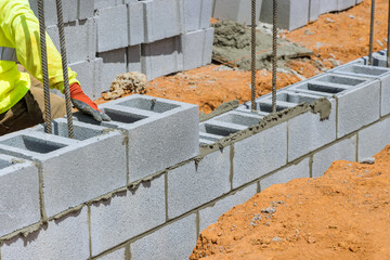 This is mason working on mounting of a wall made of the aerated concrete blocks
