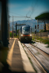 Train arrives at regular rural train station in Italy.