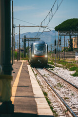 Train arrives at regular rural train station in Italy.