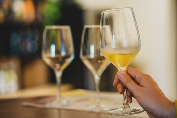 Woman is tasting white wine at a winery.