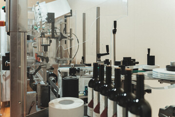 Automatic line for bottle labeling at wine factory.