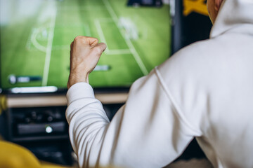 Man fottball fan watching match on a tv