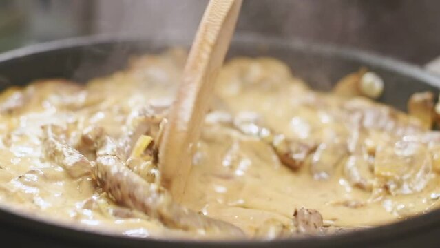 Cooking of beef stroganoff in a frying pan.
