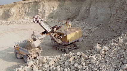 Large electric bucket excavator loads coal into a large dump truck. Mining industry. Heavy industry.