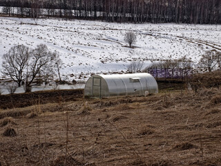 Obraz premium plastic greenhouse on the bank of the river