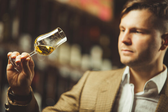 Portrait of male sommelier tasting whiskey at cellar.