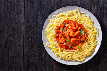 shrimps in tomato sauce with pasta, top view