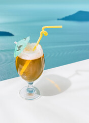 Glass of delicious lemonade isolated over sea landscape background. Refreshing drink