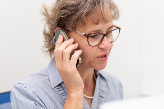 Mature Business Woman Holding Phone To Ear