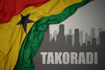 abstract silhouette of the city with text Takoradi near waving colorful national flag of ghana on a gray background.