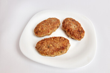 Fried meatballs on a white plate.