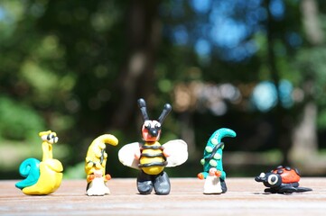 A figure of a gnome, a bee, a ladybug and a snail in close-up. Fairy-tale characters.