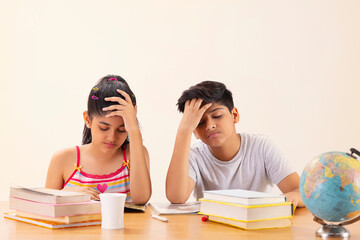 Portrait of stressed girl and boy doing homework 