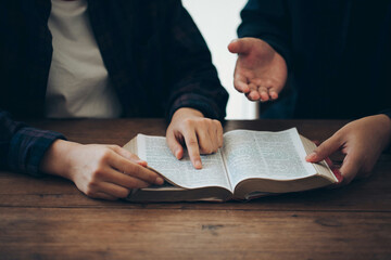  Two Christian friends read and study the bible at home and pray together. Studying the Word Of God With Friends.Sunday readings, concept studying the word of god.