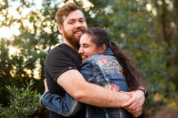 Happy young people hug with man looking at the camera