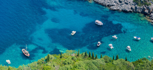 Aerial view of boats close to Limni Beach Glyko, on the island of Corfu. Greece. Where the two beaches are connected to the mainland providing a wonderful scenery. Unique double beach.
