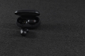 black wireless headphones with a black background