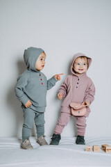 Baby fashion. Unisex gender neutral clothes for babies. Two Cute baby girls or boys in cotton set