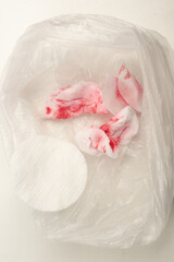 Used cotton pads after removing nail polish in a cellophane bag.