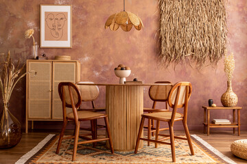 Stylish boho vintage dining room interior with poster mock up. Round table with rattan chair, commode and plants. Brown wall and rattan lamp. Mock up poster. Template.
