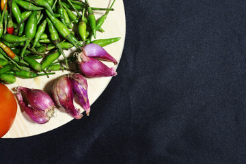 red onion and green chili with a black background