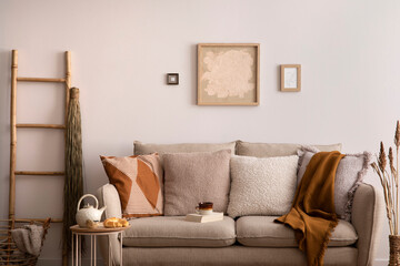 The stylish composition of living room interior with beige sofa with brown carpet, pillow, plaid,...