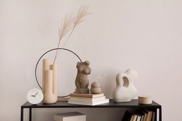 The stylish composition of minimalistic interior with black commode vase with dried flowers,...