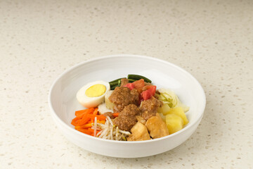 Gado Gado, Indonesian traditional vegetable salad with peanut sauce, rice cake, tofu and egg
