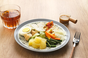 Gado Gado, Indonesian traditional vegetable salad with peanut sauce, rice cake, tofu and egg
