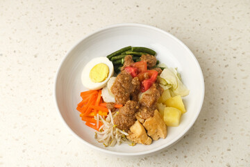 Gado Gado, Indonesian traditional vegetable salad with peanut sauce, rice cake, tofu and egg

