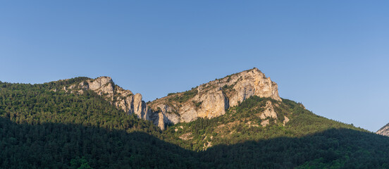 Fototapeta na wymiar Scenic summer afternoon landscape panoramic view of rocky mountain ridge and forest under bright blue sky in the Boulzane river valley near Gincla, Aude, France