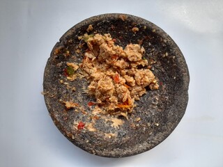 mashed tempeh sambal in mortar, top view on a white background. healthy food background concept, homemade food, spicy, hot, meal, cuisine, gourmet, dish, cooking, restaurant, breakfast, lunch, dinner