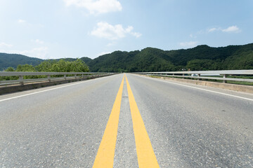 A two-lane road stretching out under the blue sky.
