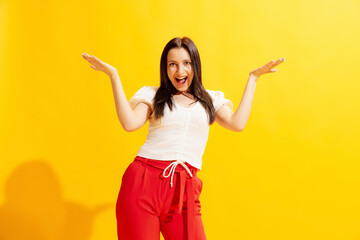 Studio shot of young beautiful woman in summer casual style outfit isolated on bright yellow background. Concept of beauty, art, fashion, human emotions