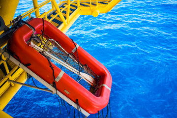 Orange lifeboats on drilling rigs for emergencies and accidents.
